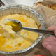 Spoon emerging from Domino's Oven-Baked Five Cheese dip with nothing but oil